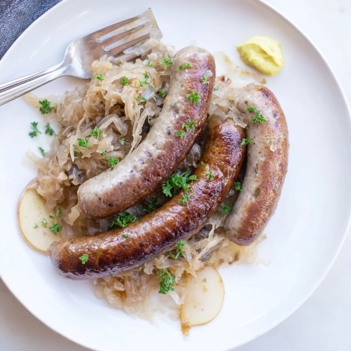 Comforting Oktoberfest Knackwurst dish garnished with fresh parsley and German mustard.  