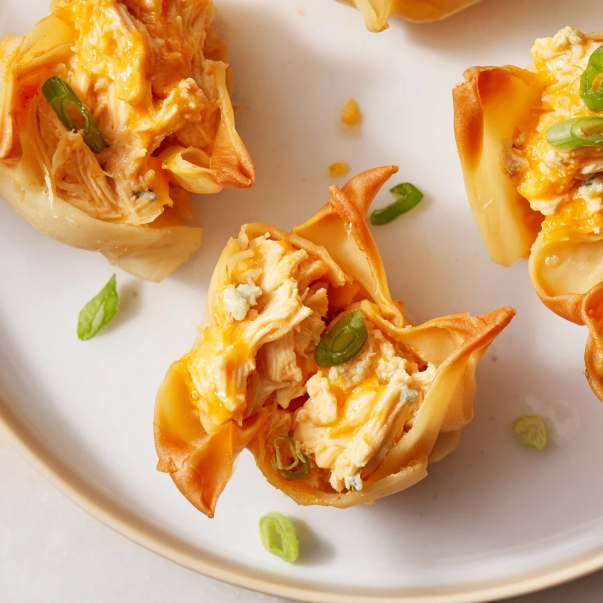Freshly baked Buffalo Chicken Dip Pinwheel Wontons on a platter, ready to be enjoyed with dipping sauce.