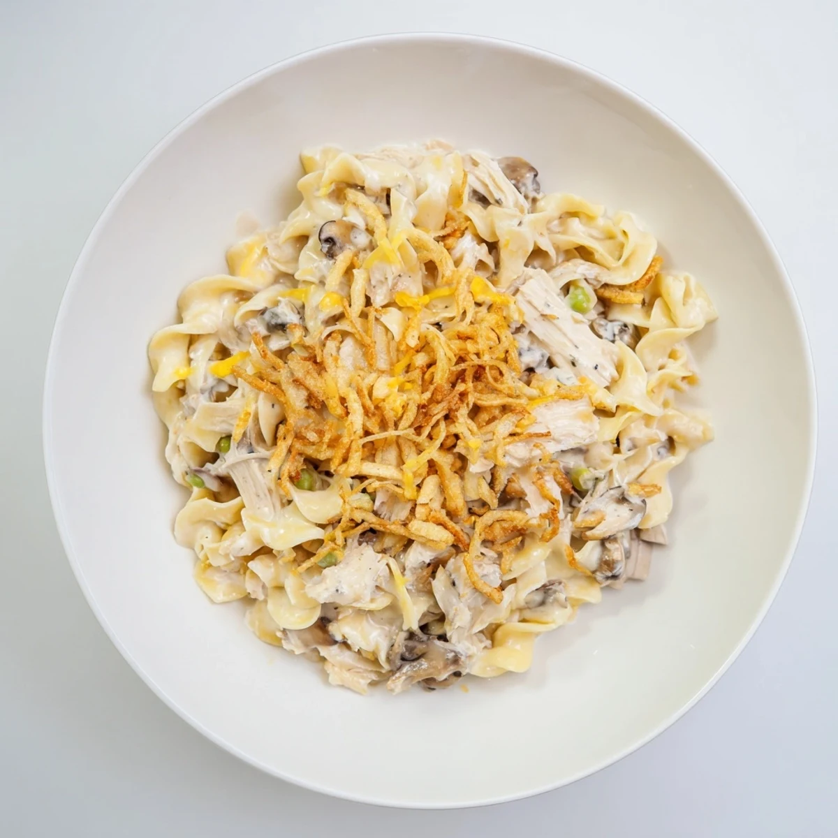 Creamy tuna noodle casserole with golden, crispy onions; a rich, comforting, baked dish.