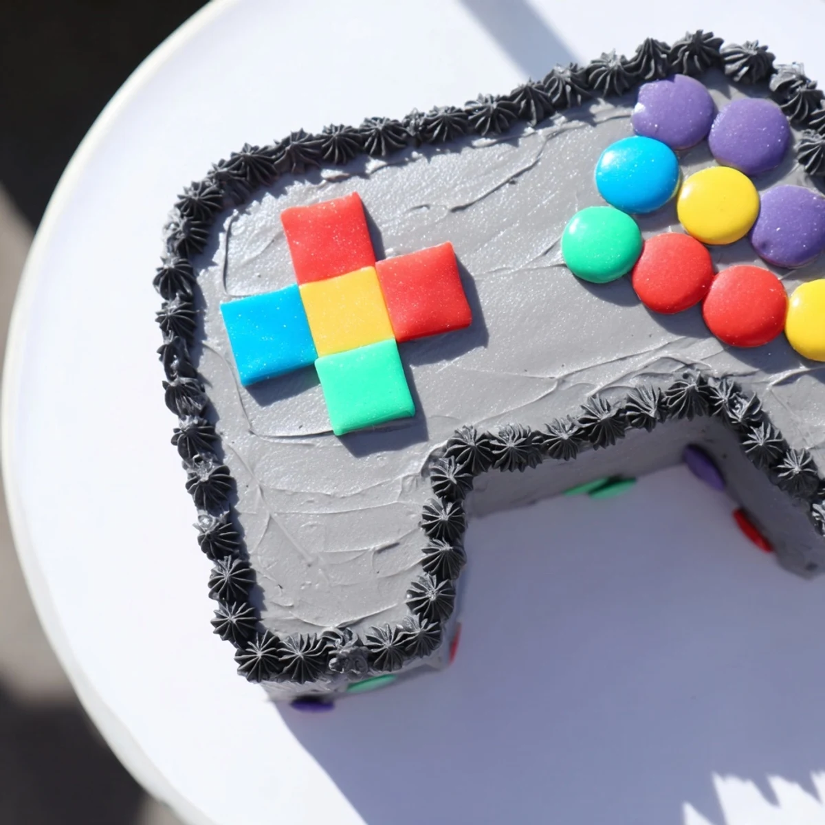 Delicious Pixel Perfect Video Game Controller Board cake with candy buttons and licorice cables, so fun!