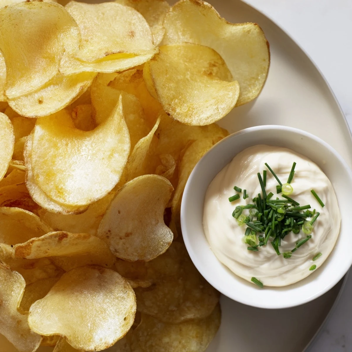 Crispy potato chips alongside creamy onion dip, a perfect appetizer for any occasion.