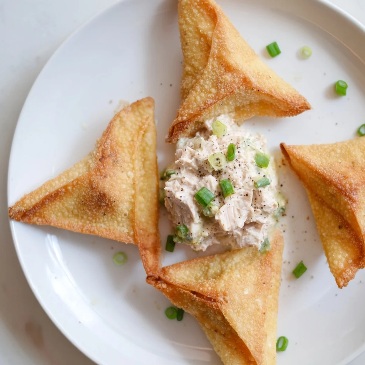 Golden-brown Air Fryer Lumpia Chips, ready to dip into the savory chicken cream cheese alongside.