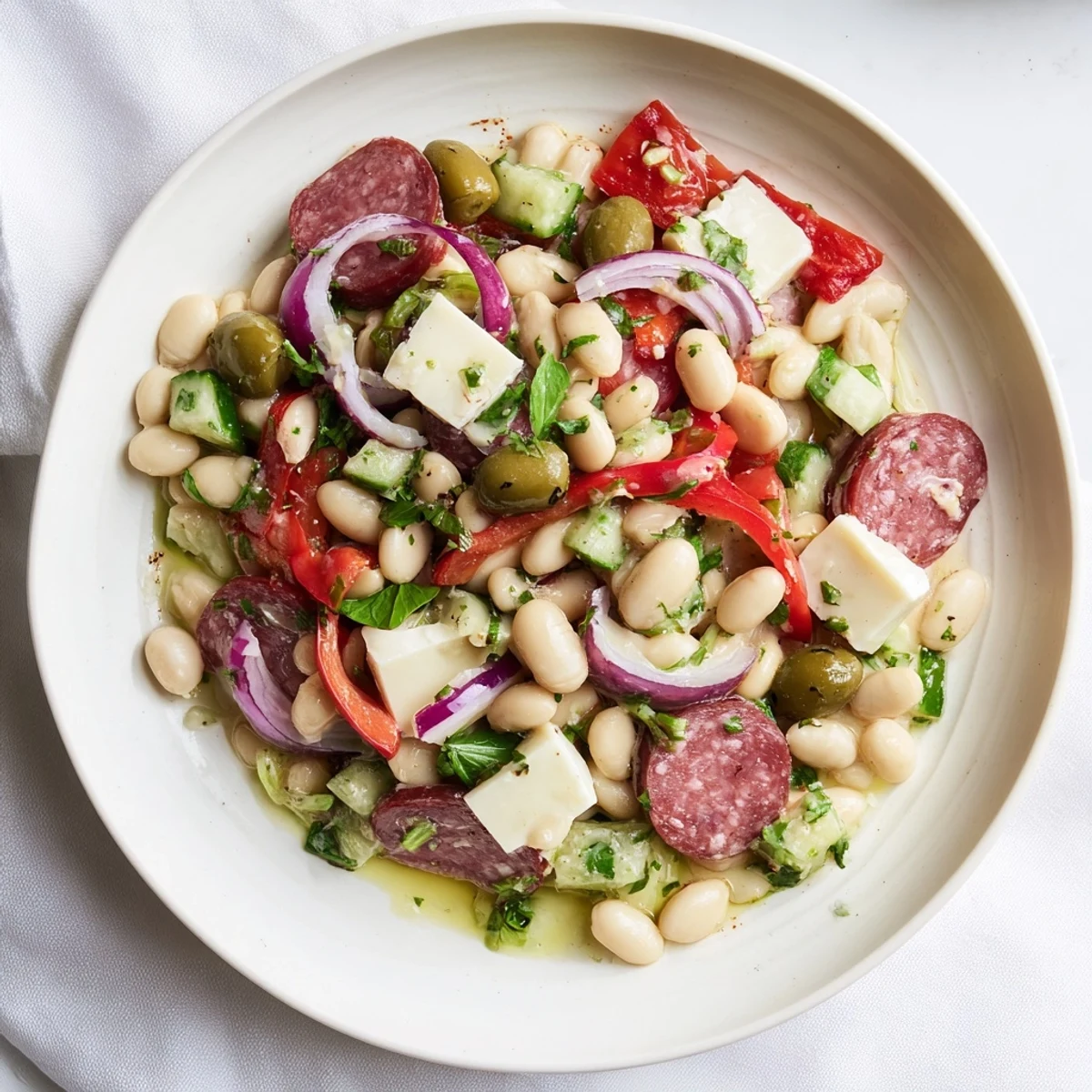 Italian Antipasto Bean Salad: A colorful bowl of chilled beans, salami, and provolone, ready to eat.