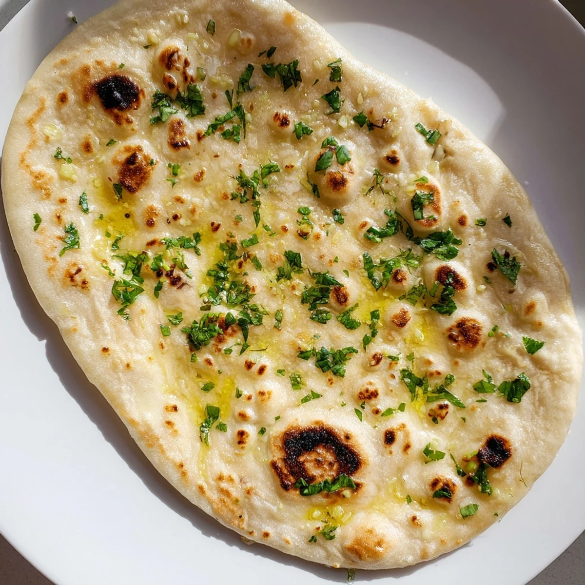 Freshly made garlic naan, perfect for scooping up curries or any flavorful Indian dishes.