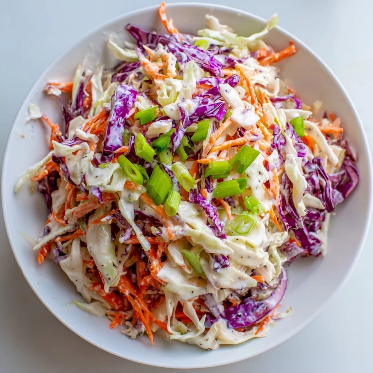 This fresh Quick Coleslaw Salad features vibrant shredded cabbage and carrots, coated in creamy, tangy dressing.