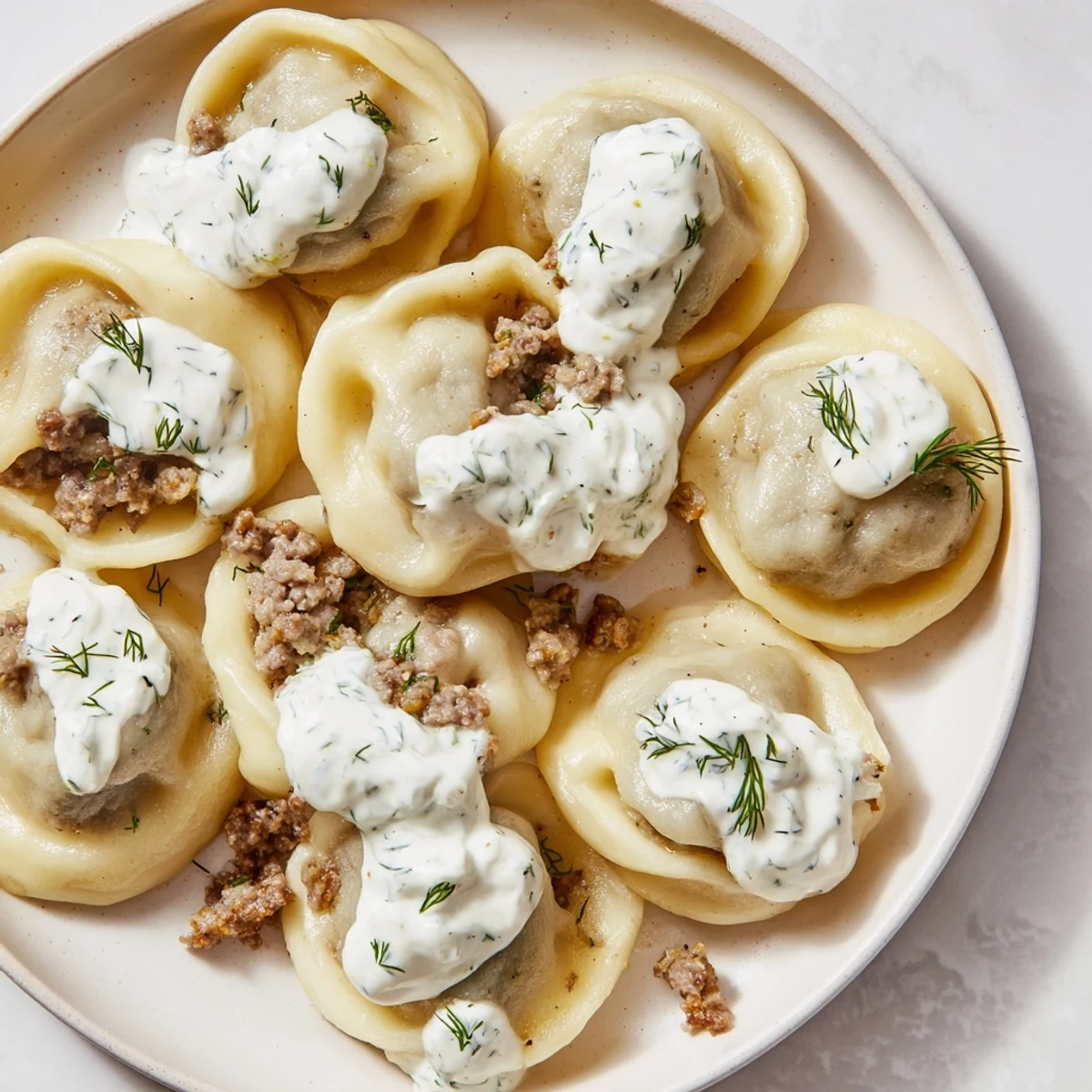 Golden-brown Russian pelmeni, steaming hot and ready to be enjoyed with a dollop of tangy sour cream.