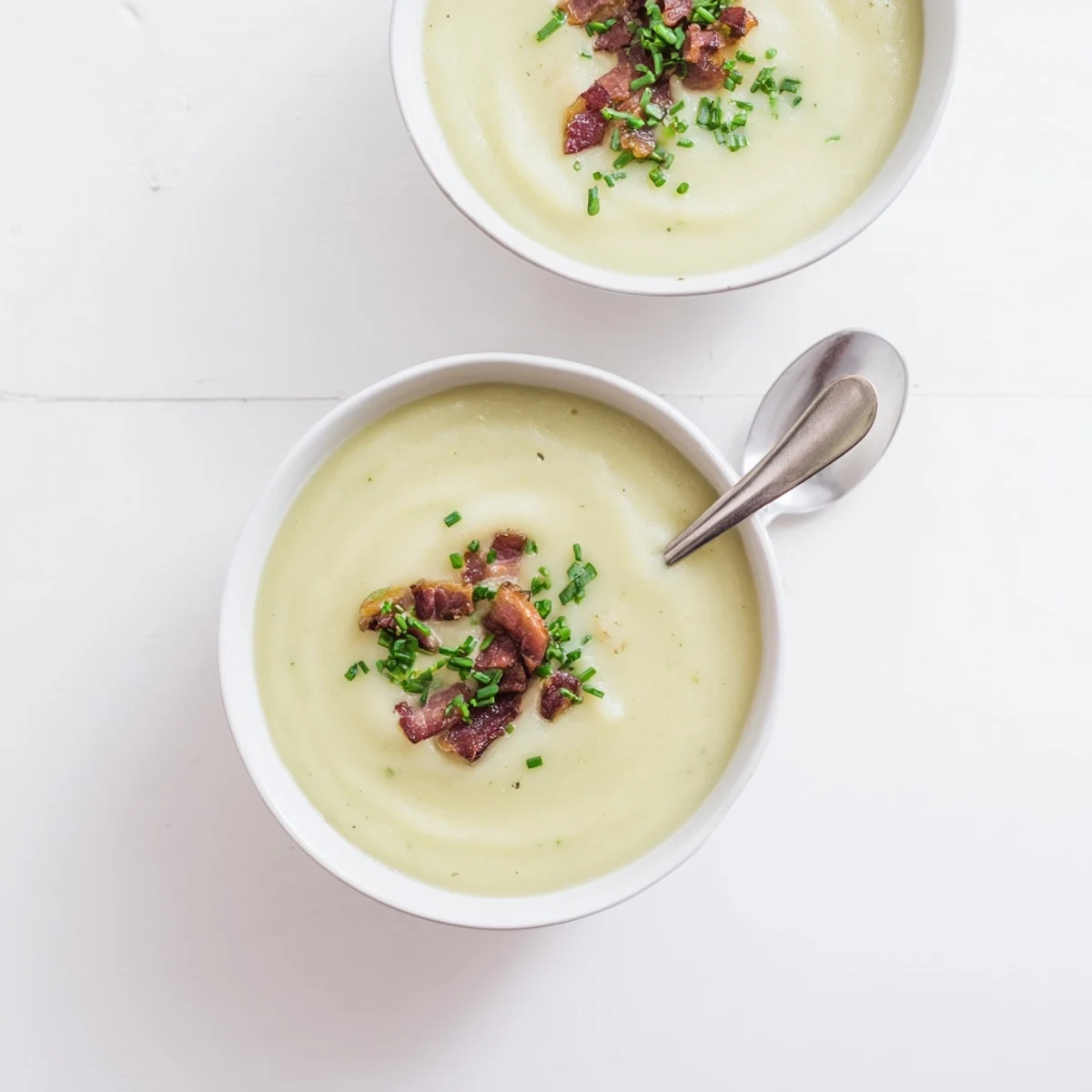 Creamy Celeriac Soup with Crispy Bacon served steaming in a rustic bowl, garnished with fresh chives.