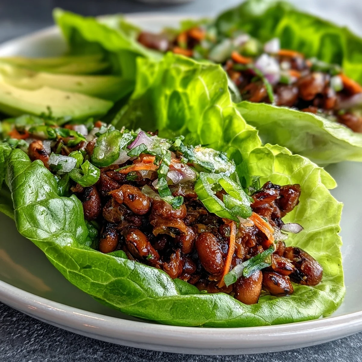 Black-Eyed Pea Lettuce Wraps filled with seasoned peas, diced red bell pepper, and avocado, resting on a rustic wooden table.