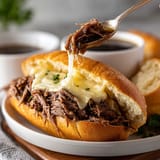 A sandwich is being cut with a fork.