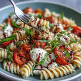 Creamy burrata melts over Summer Caprese Pasta with fresh basil and tomatoes.