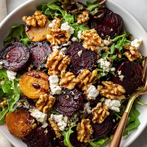 A bowl of salad with beets, walnuts, and blue cheese.