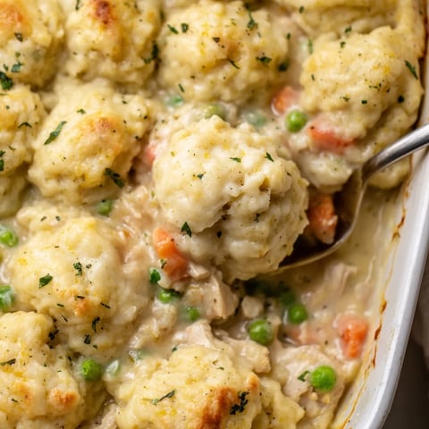 Hearty chicken and dumplings casserole, bubbling with creamy sauce and fresh veggies.  