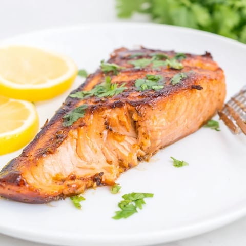 Juicy honey ginger grilled salmon glistening with a caramelized glaze, perfect for summer meals.  