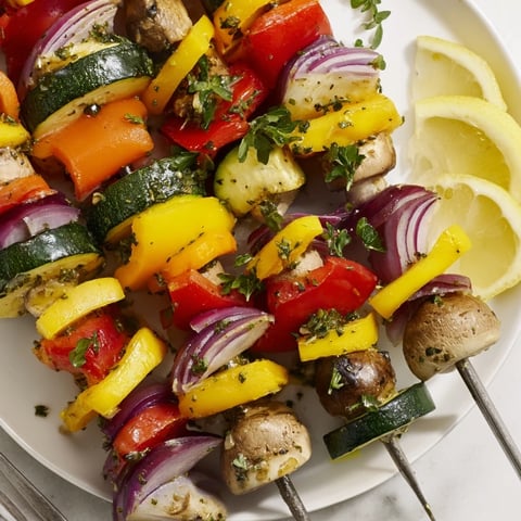 Colorful lemon herb veggie skewers glisten with olive oil and fresh herbs.  