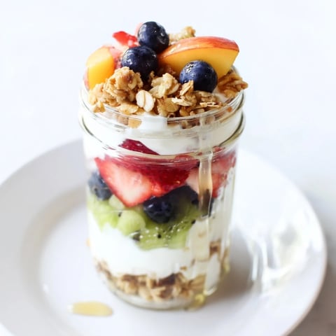 A layered Yogurt Parfait with colorful berries and crunchy granola, a delightful, fresh breakfast.