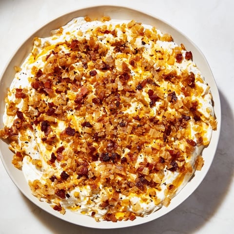 Creamy Caramelized Onion and Bacon Dip, a party appetizer with golden onions and crispy bacon.