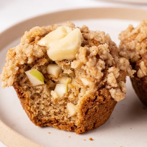 Golden-brown Tasty Apple Muffins, fresh from the oven, with a buttery, cinnamon crumb topping.