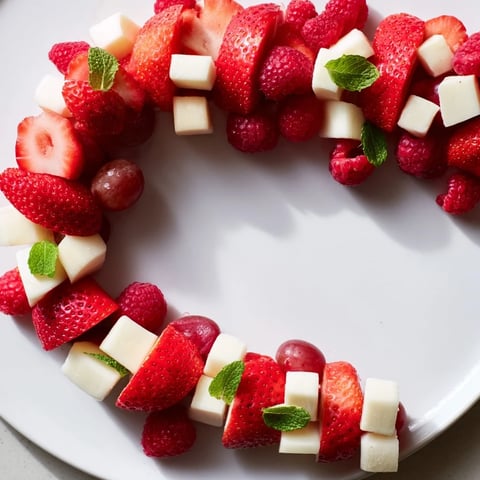 Candy Cane Stripe Fruit and Cheese platter with vibrant red fruits and white cheeses.