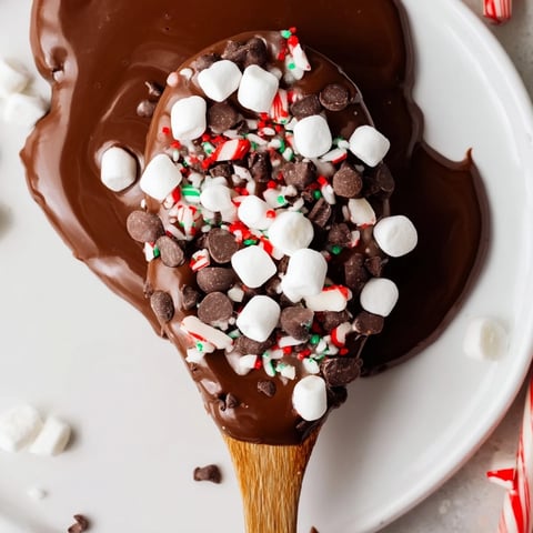 Decadent hot chocolate spoon toppings board, boasting colorful marshmallows, crunchy peppermint, and chocolate chips.