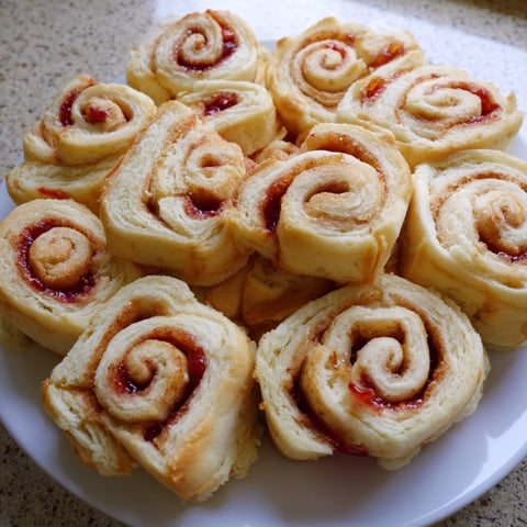 Colorful, quartered peanut butter and jelly pinwheel rolls, a simple sandwich perfect for kids' lunches.