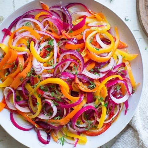 Vibrant The Spinning Top salad features colorful, thinly shaved vegetables and fresh herbs artfully arranged.