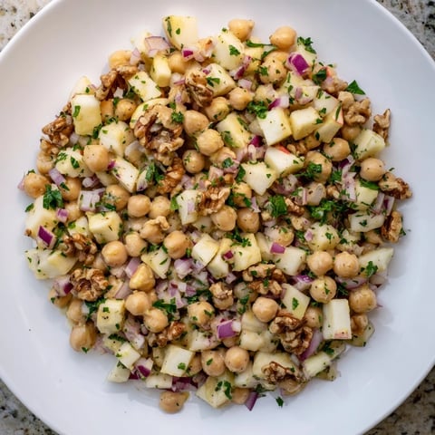 Fall Harvest Apple and Chickpea Salad: A colorful bowl of chickpeas, apples, and walnuts, ready to enjoy.