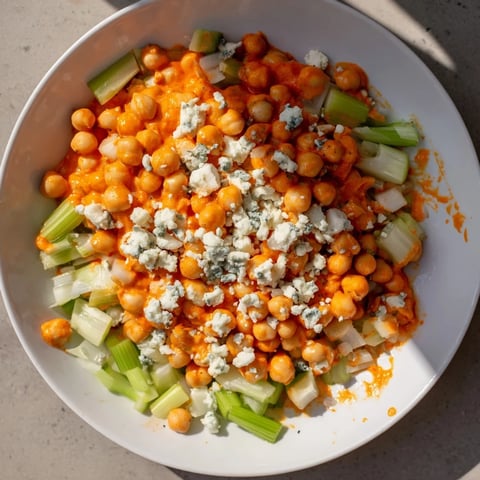 Vibrant photo showcases buffalo chicken bean salad, a spicy vegetarian delight with blue cheese crumbles.