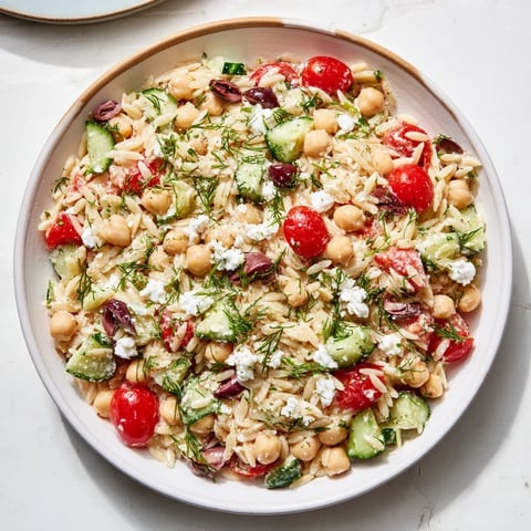 Fresh Greek Lemon-Orzo Bean Salad with bright tomatoes, cucumbers, and a zesty vinaigrette.