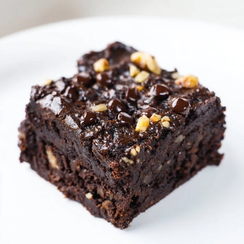 Fudgy Black Bean Brownies, topped with melted chocolate, offer a rich, gluten-free dessert experience.