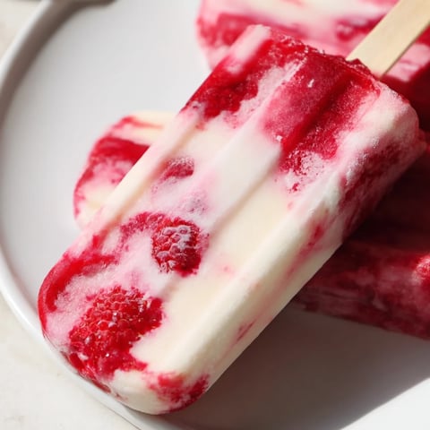 Vibrant Raspberry Coconut Ice Pops: layers of red raspberry puree and creamy coconut milk, perfect for summer.