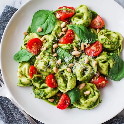 Fresh Pesto Tortellini Salad, a colorful mix of pasta, basil pesto, and bright cherry tomatoes.