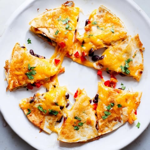 Golden-baked Blooming Quesadilla Ring with melted cheddar and Monterey Jack cheese, arranged like a flower on a platter with a side of salsa and sour cream for dipping.  
