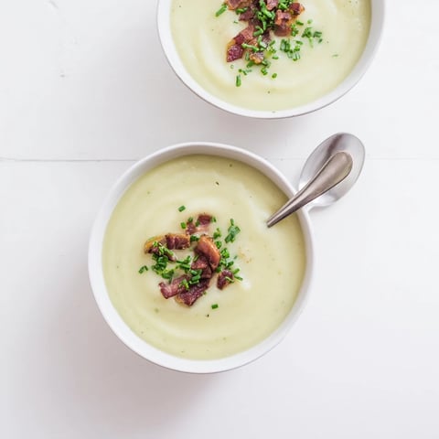 Creamy Celeriac Soup with Crispy Bacon served steaming in a rustic bowl, garnished with fresh chives.