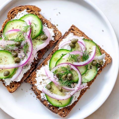 Hearty German black bread toasts topped with creamy goat cheese and fresh dill.  