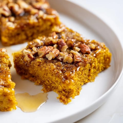 Delicious homemade Cinnamon Maple Pumpkin Bars with warm spices and nutty topping.  
