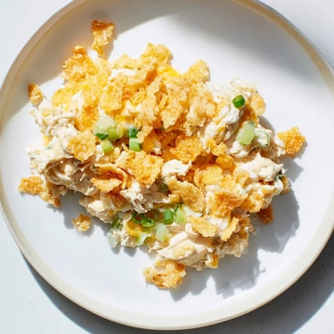 A close-up of a bubbling, creamy Neiman Marcus Chicken Casserole topped with golden, crunchy crackers.