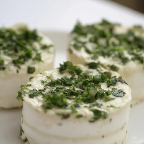 These whimsical Mossy Stones are creamy goat cheese rolls, heavily coated in green herbs.