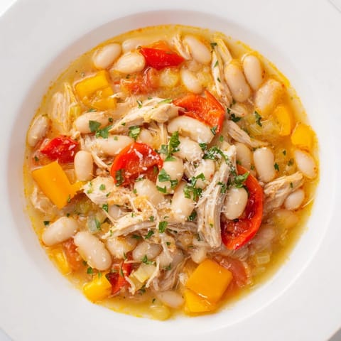 Close-up shot showing the vibrant color of this hearty White Bean and Roasted Red Pepper Chicken stew.