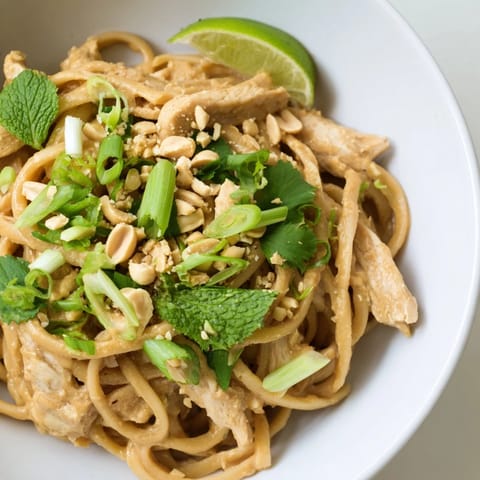 Creamy, flavorful Thai Peanut Chicken Pasta, beautifully plated with colorful fresh cilantro and mint.