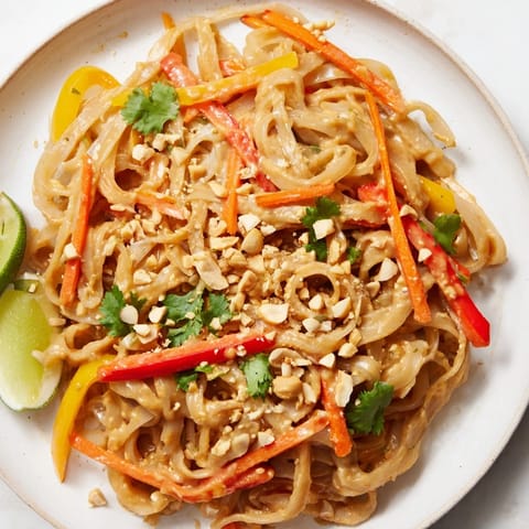 Close-up of freshly made spicy peanut noodles, with a rich, creamy sauce and crunchy peanuts.
