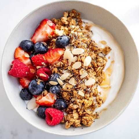 A vibrant Dry Yogurt Bowl showcasing layered Greek yogurt, topped with colorful berries and granola.