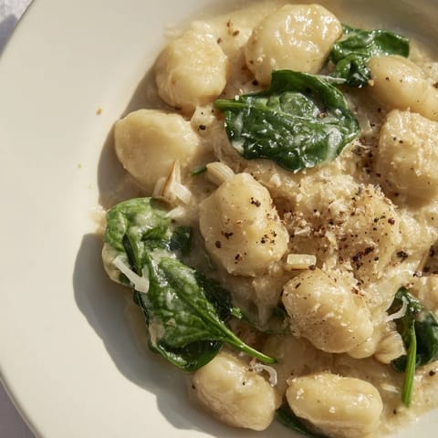 A close-up of creamy garlic gnocchi; tender gnocchi coated in a rich, garlic cream sauce, ready to eat.