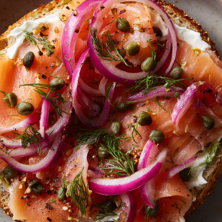 A close up of a sandwich with salmon, onions, and capers.