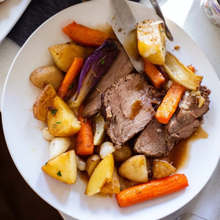 Comforting Sunday pot roast served with rich broth and colorful roasted vegetable medley.