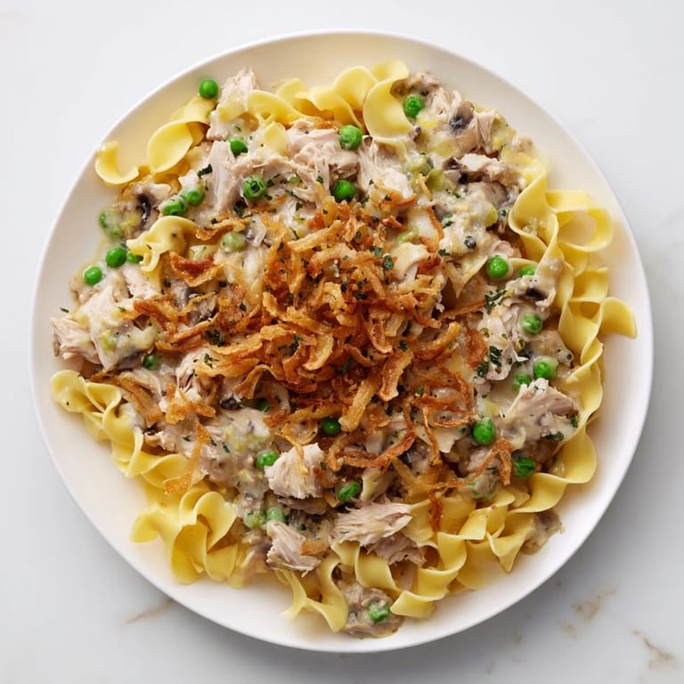 Tender egg noodles and flaky tuna baked in a creamy sauce, a classic tuna noodle casserole delight.