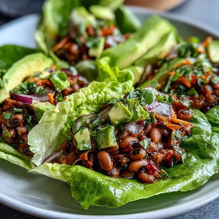 Black-Eyed Pea Lettuce Wraps plated with extra diced veggies and lemon wedges, perfect for a healthy vegetarian appetizer.