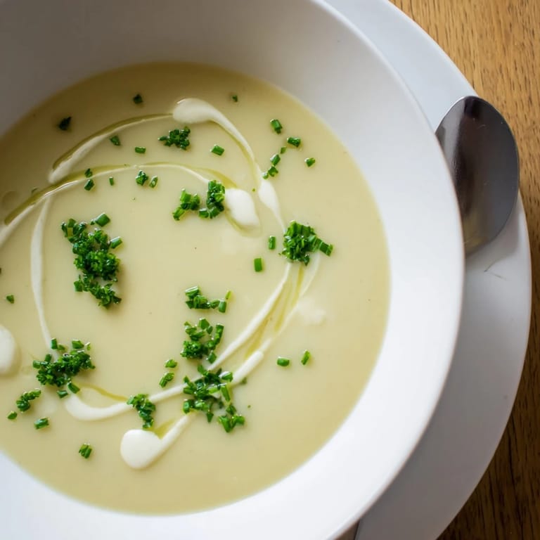 Velvety Creamy Celery Root Bisque being ladled from a pot, steam rising, ideal for a refined starter.