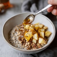 A spoon is being used to stir a bowl of mashed cauliflower.