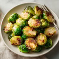A plate of cooked brussel sprouts.