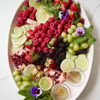 Vibrant Bubbly Bar Garnish Platter showcasing fresh berries, citrus wheels, and edible flowers arranged elegantly.